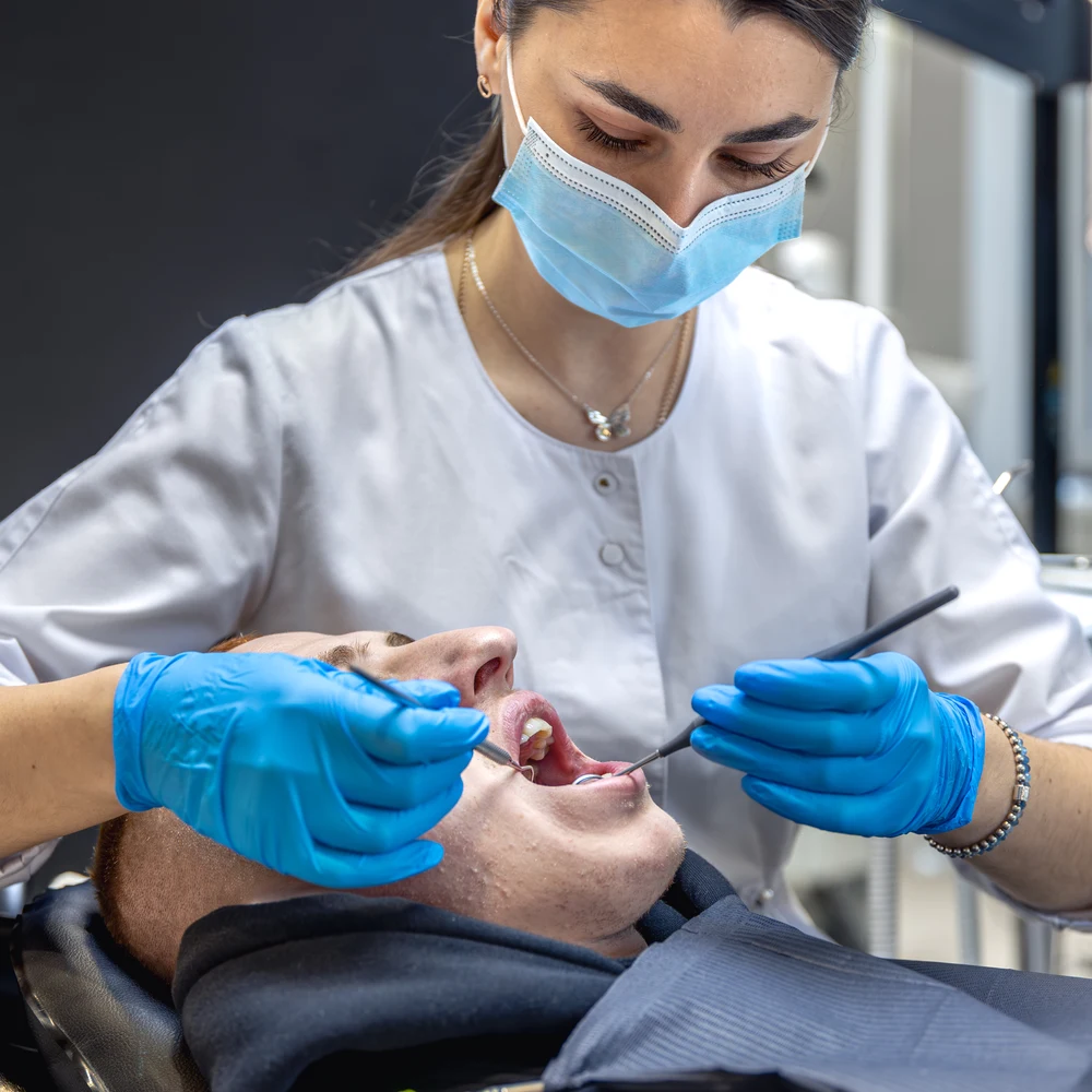 female dentist treats patients teeth stomatologist working with professional equipment ezgif.com optiwebp