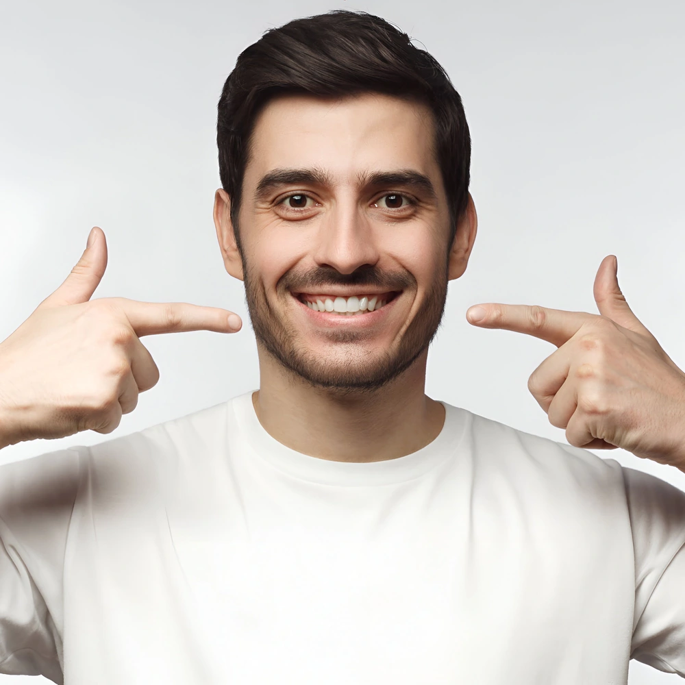 portrait smiling young man pointing his perfect natural white teeth after whitening treatment dental clinic ads concept ezgif.com optiwebp